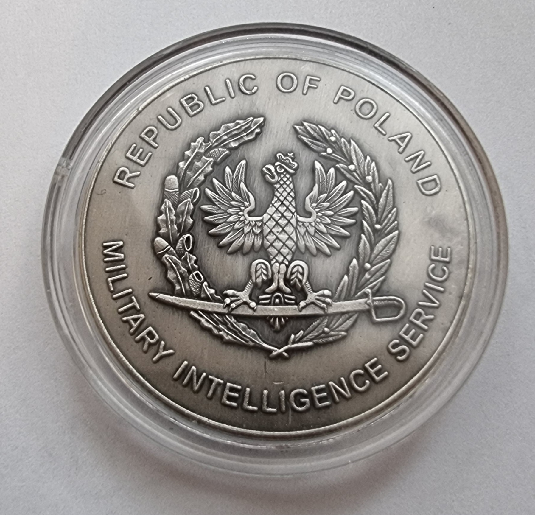 Pamiątkowy medal z godłem Rzeczypospolitej Polskiej i napisem Military Intelligence Service.